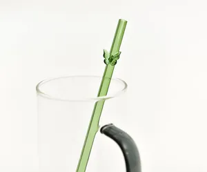 Detailweergave van een groen borosilicaatglazen rietje met een decoratieve glazen vlinder