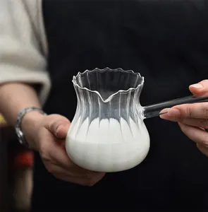 Detail view of a handmade striped glass milk pitcher with a sleek handle and eagle spout