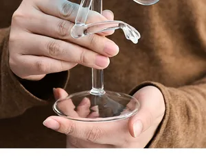 Nahaufnahme eines kreativen Stiels in Flamingo-Form an einem klaren Cocktailglas.