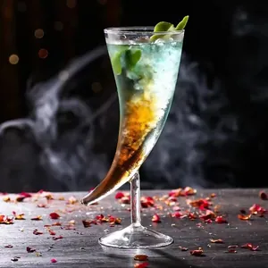 Gros plan d'un verre à cocktail unique en forme de corne avec boisson colorée.