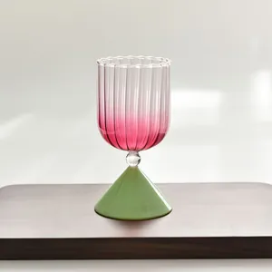 Elegant pink gradient ribbed glass goblet with green base for desserts and cocktails
