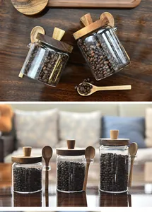 Detailed view of three sizes of glass coffee jars with wooden lids and spoons