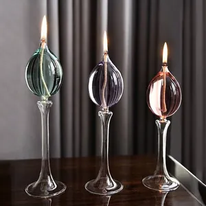 Juego de tres elegantes lámparas de aceite de vidrio con líquidos de colores y tallos finos