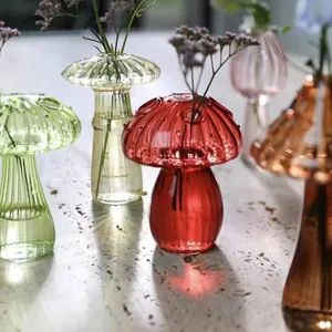 Detailed macro view of colorful mushroom-shaped ribbed glass vases with dried flowers.