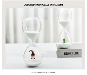 Close-up of Christmas glass hourglass with white sand and tree figurine