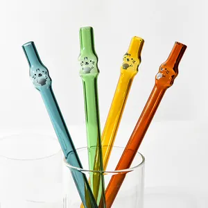 Close-up view of four colorful heat-resistant glass straws featuring cute animal designs