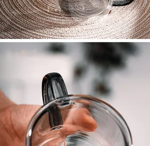 Close-up detail of black handle on transparent double-walled glass coffee mug