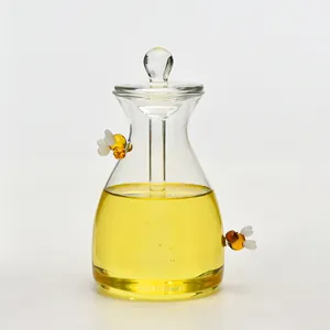 Detailansicht eines kreativen Honigglases aus klarem Glas mit dekorativen Bienenakzenten