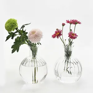 Elegantes Set aus zwei Vintage-Glasvasen mit gerippter Struktur und frischen Blumenarrangements