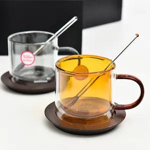 Double-walled amber and clear glass coffee cup set with wooden saucers and glass spoons
