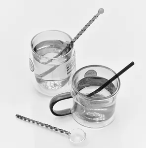 Detailansicht von hitzebeständigen Glasrührlöffeln und Kaffeetassen in Graustufen