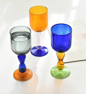 Close-up of creative colorful contrasting glass wine goblets with unique vibrant stems