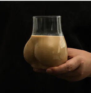 Vista detallada de un vaso único con forma de glúteos lleno de un cremoso té con leche