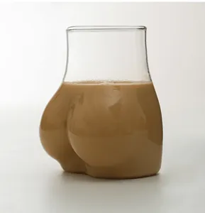 Vista detallada de un vaso original con forma de glúteos lleno de un cremoso té con leche rico