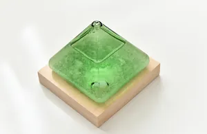 Close-up of green pyramid storm glass weather forecast bottle on wooden base