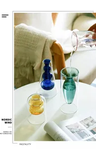 Nordic double-layer colored glass vases for hydroponics on a stylish white table.