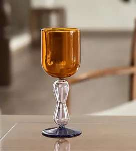 Artistic amber glass goblet with double sphere stem and blue base for elegant dining