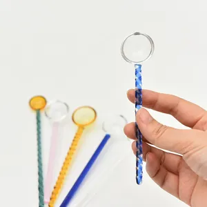 Mano che tiene un cucchiaio di vetro colorato con manico lungo a spirale blu per caffè