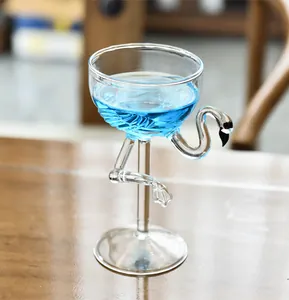 Detaillierte Nahaufnahme eines kreativen Cocktailglases in Flamingoform auf Holztisch