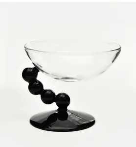 Detail einer kreativen Dessertschale aus Glas mit schwarzem Perlenstiel