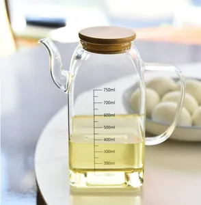 Detailed close-up of clear glass oil dispenser bottle with bamboo lid and 750ml scale