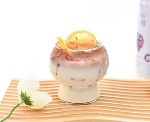 Close-up of a handmade ribbed glass dessert cup featuring a layered yogurt drink