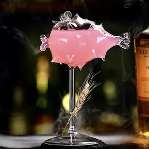 Copa artística de martini de vidrio con forma de pez globo con bebida rosada