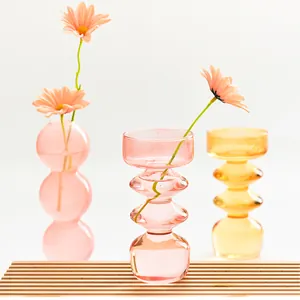 Decorative pink and amber bubble-shaped colored glass vases for modern home decor.
