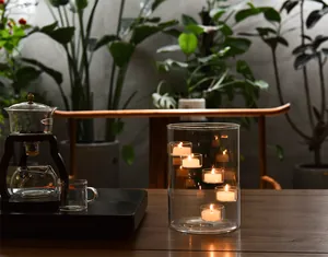 Atmospheric detail of a large glass candle holder with multiple glowing tealights.