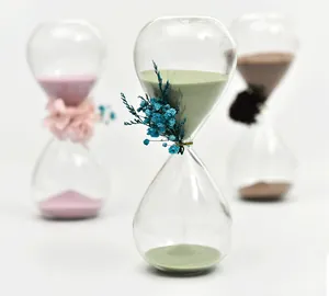 Detailed view of a Nordic glass hourglass timer with elegant dried flower decoration