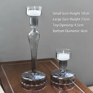 Detailed view of grey ribbed glass candle holders in two different sizes.