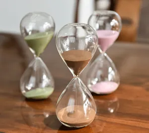 Decorative set of three creative colored glass sand hourglass timers in green brown and pink