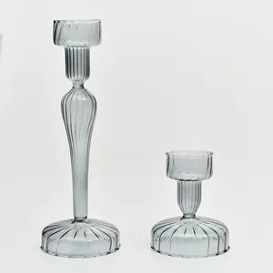 Detail view showing the elegant ribbed texture of two grey-tinted glass candlesticks.