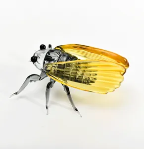 High-quality detailed macro view of a handcrafted glass cicada figurine with amber wings.