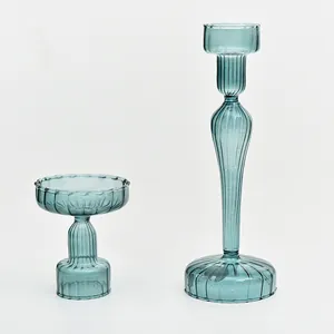 Close-up detail of elegant teal blue ribbed glass candle holders for table decor.