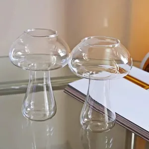 Close-up of two mushroom-shaped clear glass cocktail cups on a reflective surface