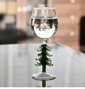 Détail d'un verre à vin créatif avec un pied festif en forme de sapin de Noël vert