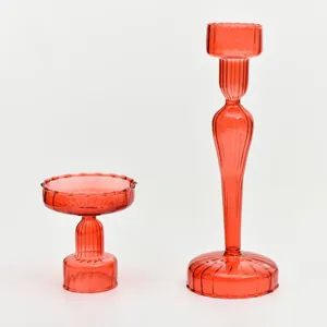 Elegant pair of red ribbed glass candle holders in different heights for table decor