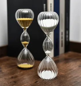 Makro-Detailansicht der dreistufigen gestreiften Glassanduhr-Timer mit gelbem und weißem Sand.