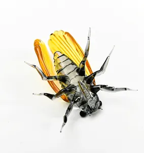 Detailed close-up of a handcrafted glass cicada figurine featuring translucent amber wings.