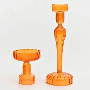 Detailed view of two vintage style ribbed orange glass candle holders for decor.