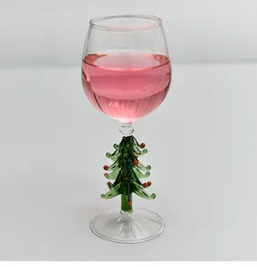 Gros plan montrant le pied festif en forme de sapin de Noël vert d'un verre à vin.