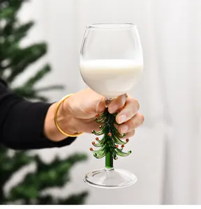 Vue détaillée d'un verre à vin créatif avec tige en forme de sapin de Noël en main
