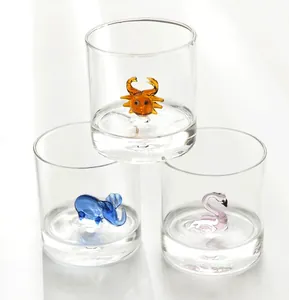 Detailed view of three glass cups with 3D animal figures inside (crab, elephant, flamingo)