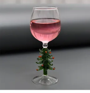 Détail du pied créatif en forme de sapin de Noël sur un verre à vin festif en verre