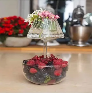 Vista dettagliata di un elegante portafrutta in vetro a due livelli con fiori e frutti di bosco
