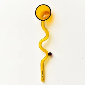 Detailed view of an amber heat-resistant glass spoon featuring a wavy handle and round head