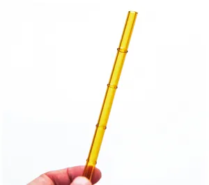Close-up of amber bamboo-shaped glass straw showing segmented texture