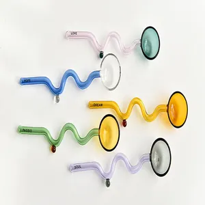 Detail of heat-resistant colorful glass spoons with wavy handles and inspiring words