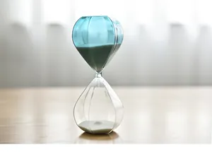 Close-up detail of a Nordic style blue and clear faceted glass sand timer hourglass